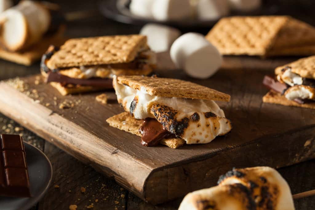 Gooey s'mores with chocolate and marshmallows on a cutting board